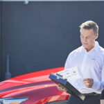 Female car owner and male service technician in front of Mazda car outside service center